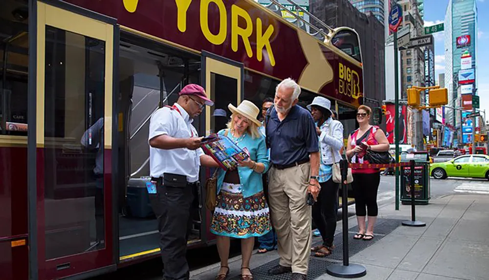 A tour guide is assisting a couple with a map in front of a sightseeing bus in a bustling city area likely offering them information about local attractions
