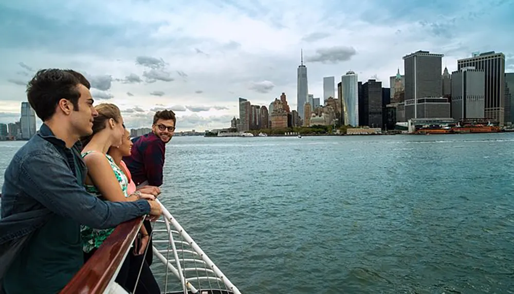 A group of people are enjoying the view of a city skyline from the deck of a boat