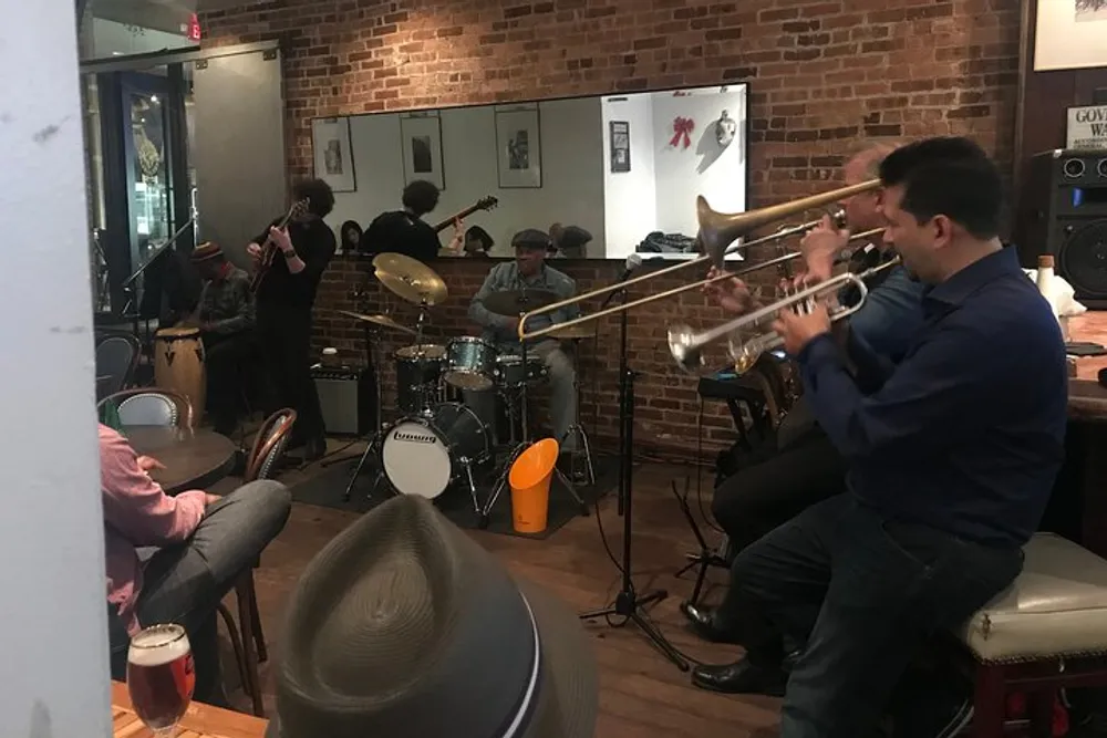 A group of musicians is performing live in a cozy venue with an audience enjoying the atmosphere