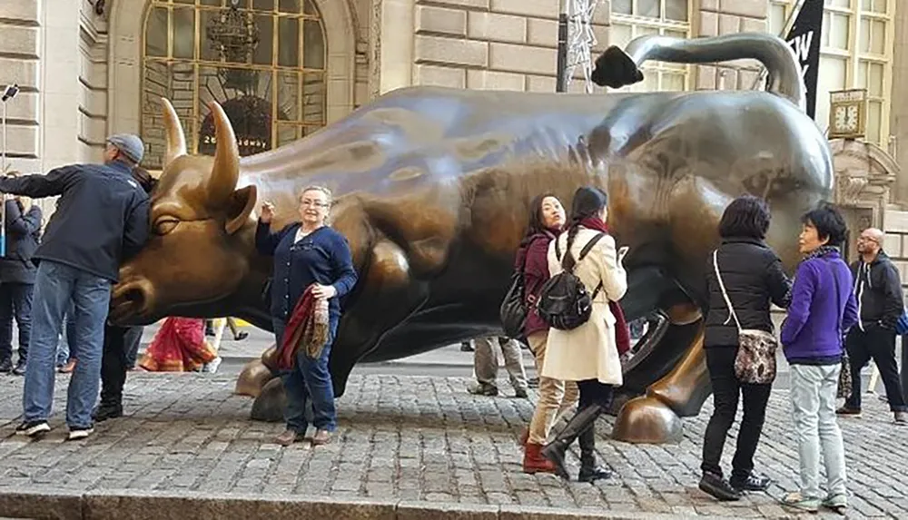 Visitors are interacting with the Charging Bull statue a famous financial icon located in New York City