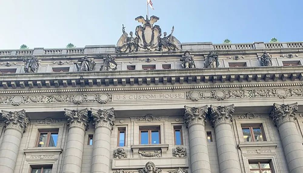 The image shows the ornate facade of the US Custom House with Corinthian columns and detailed sculptures