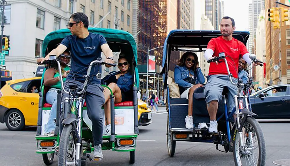 Two pedicabs are being ridden by cyclists as passengers enjoy the ride on a busy city street