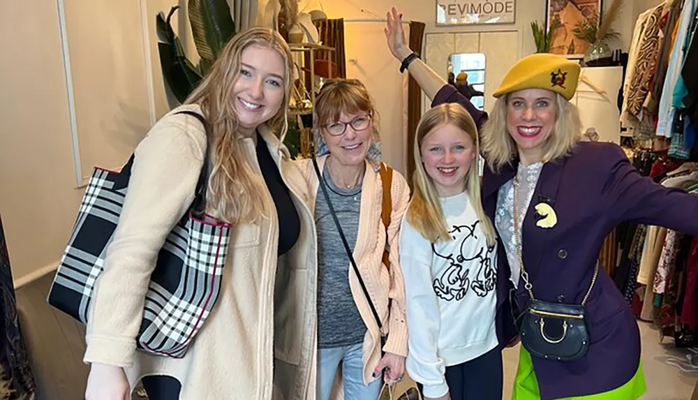 Four smiling individuals pose together for a photo inside a clothing store