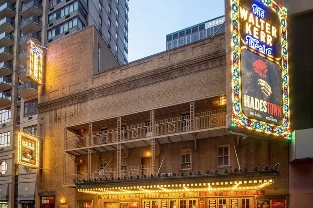 The image shows the illuminated marquee and signage of the Walter Kerr Theatre advertising the musical Hadestown