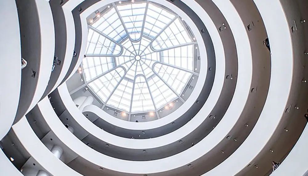 The image shows the spiraling architecture of an interior likely a museum with a glass dome at the top providing natural light