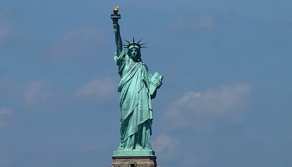 The image shows the Statue of Liberty against a clear blue sky a symbol of freedom and democracy