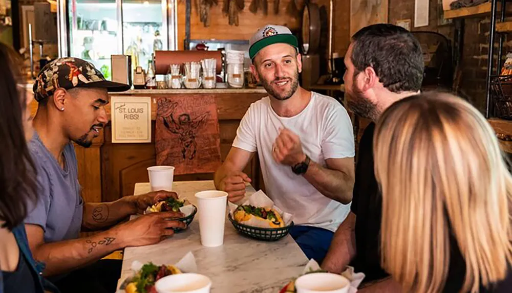 A group of four people is enjoying a meal together at a casual dining restaurant engaged in conversation